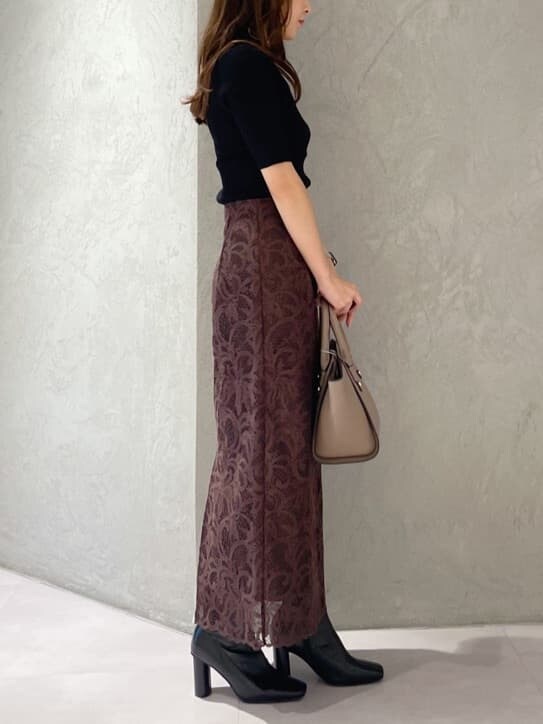 ブラウン系のハンドバッグ、ブラック系のニット/セーター、ブラック系のブーツを着用したレディースの夏コーディネートの4枚目の写真