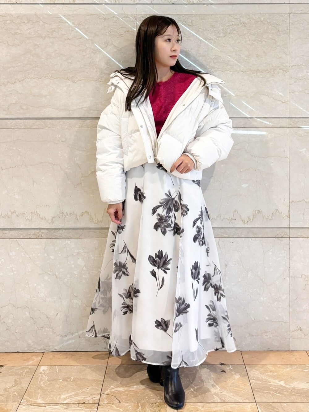 ホワイト系のスカート、ブラック系のブーツ、レッド系のカーディガン/ボレロを着用したレディースの冬コーディネートの8枚目の写真