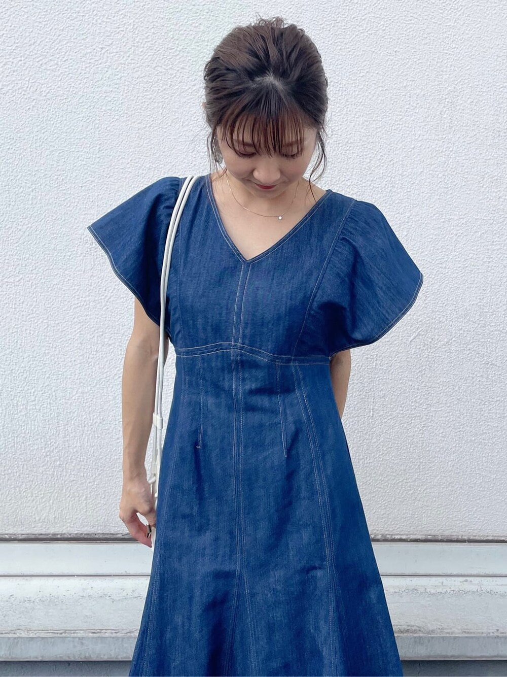 ブルー系のワンピース、ブラウン系のサンダル、ホワイト系のハンドバッグを着用したレディースの夏コーディネートの4枚目の写真