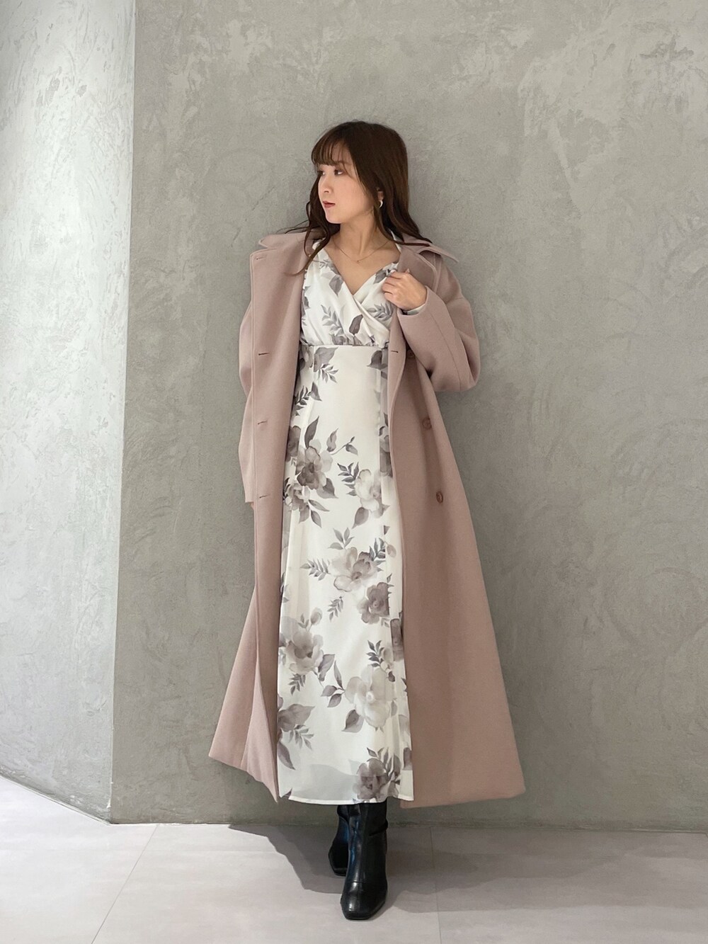 ホワイト系のワンピース、ベージュ系のステンカラーコート、ブラック系のブーツを着用したレディースの冬コーディネートの4枚目の写真