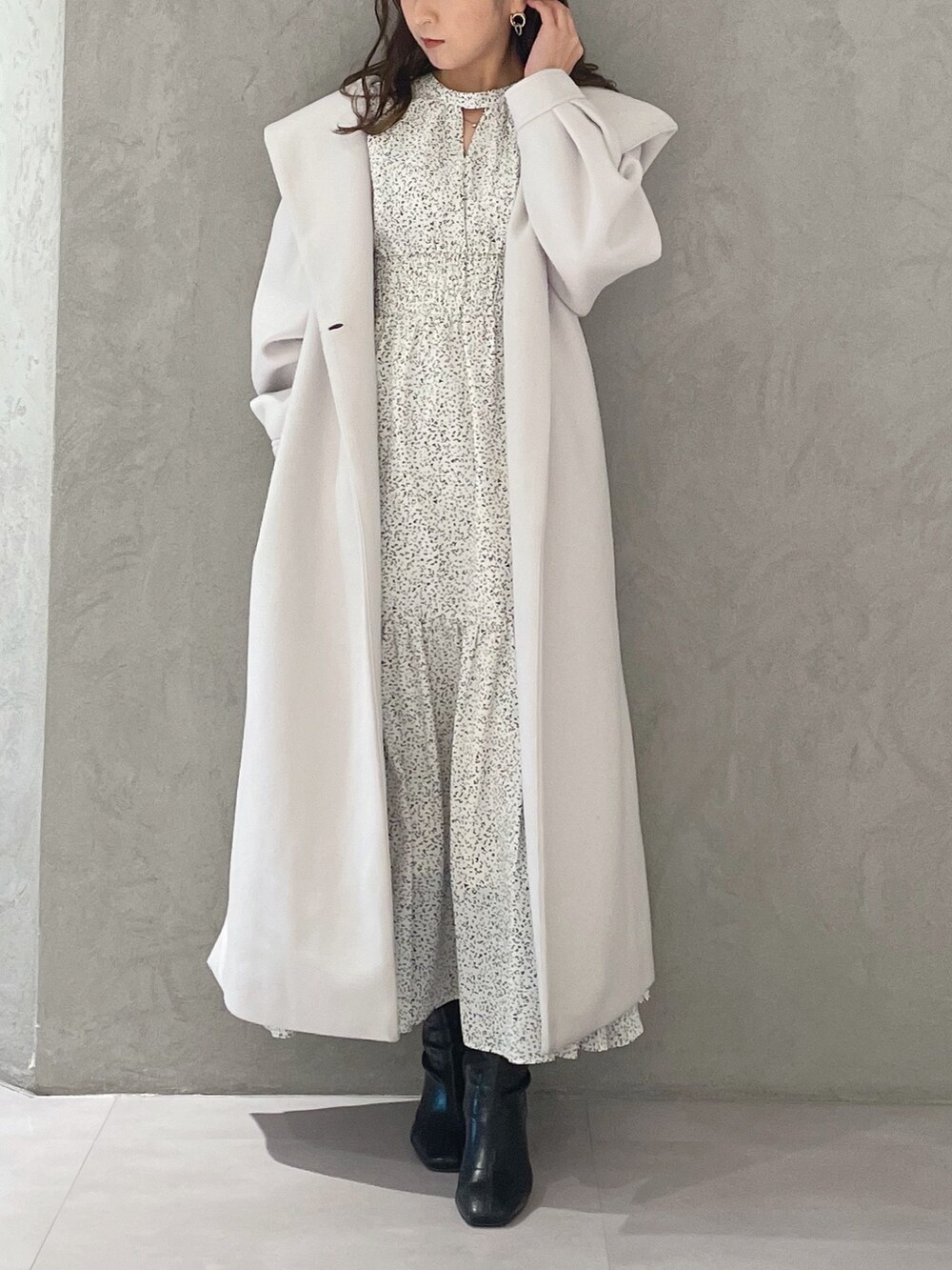 ホワイト系のワンピース、ホワイト系のチェスターコート、ブラック系のブーツを着用したレディースの冬コーディネートの5枚目の写真