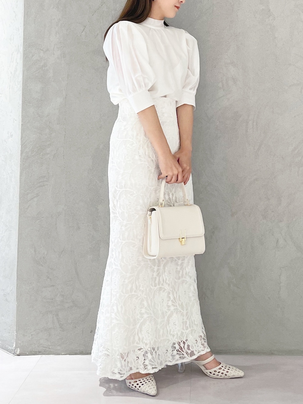 ホワイト系のスカート、ホワイト系のショルダーバッグ、ホワイト系のパンプスを着用したレディースの春コーディネートの4枚目の写真