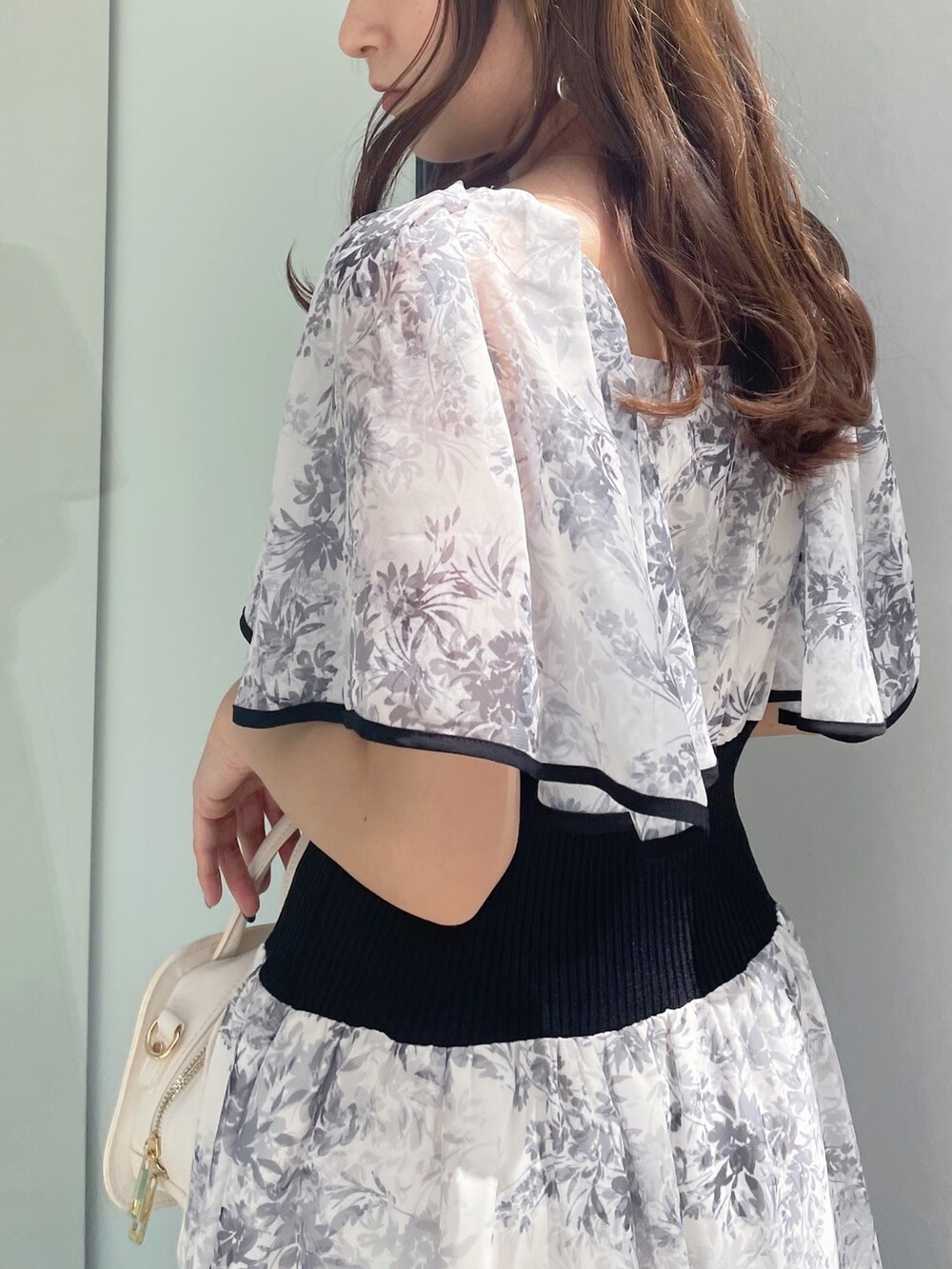 ブラック系のサンダル、ホワイト系のハンドバッグ、ホワイト系のワンピースを着用したレディースの春コーディネートの9枚目の写真