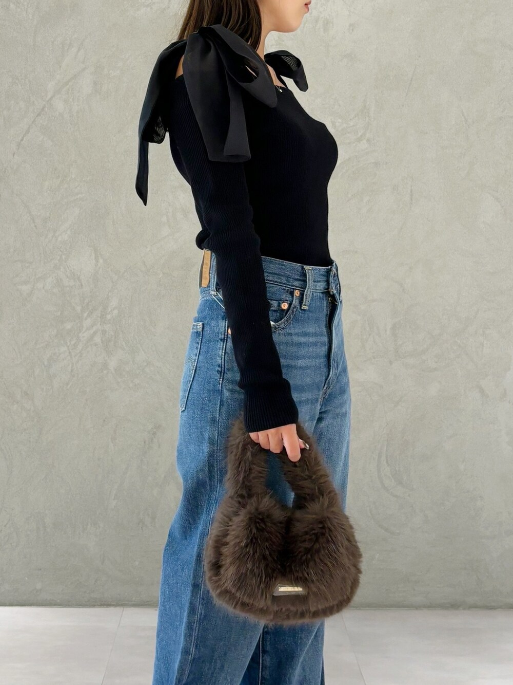 ブラウン系のハンドバッグ、シルバー系のパンプス、ブラック系のニット/セーターを着用したレディースの秋コーディネートの7枚目の写真