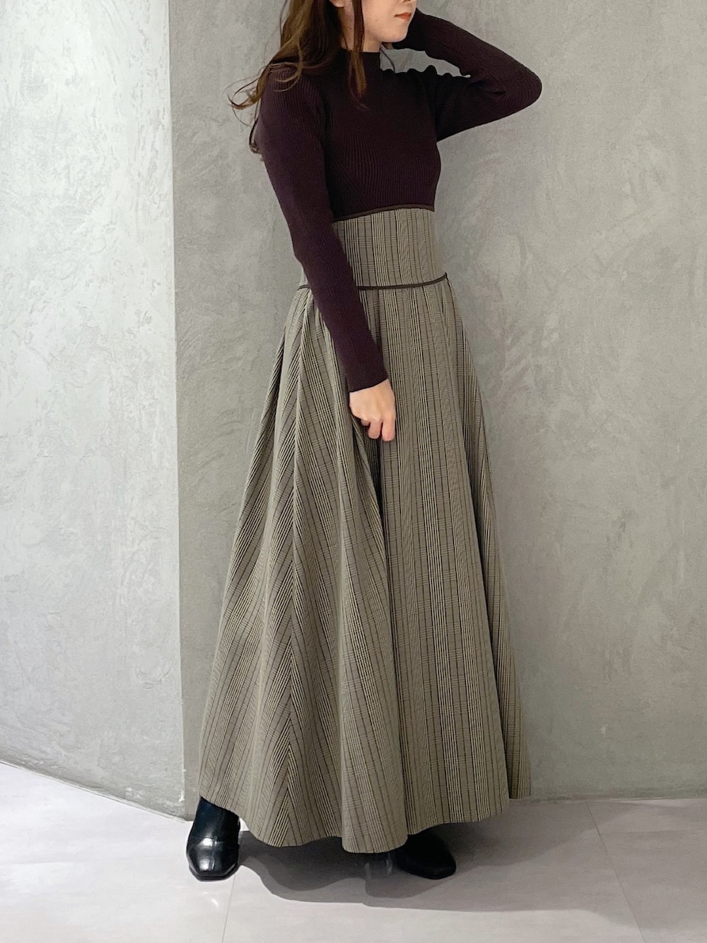 ブラウン系のワンピース、ブラック系のブーツを着用したレディースの冬コーディネートの5枚目の写真