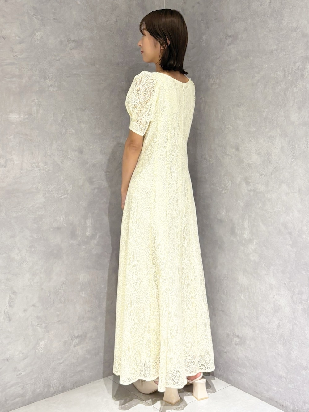 イエロー系のワンピース、ホワイト系のパンプスを着用したレディースの春コーディネートの3枚目の写真