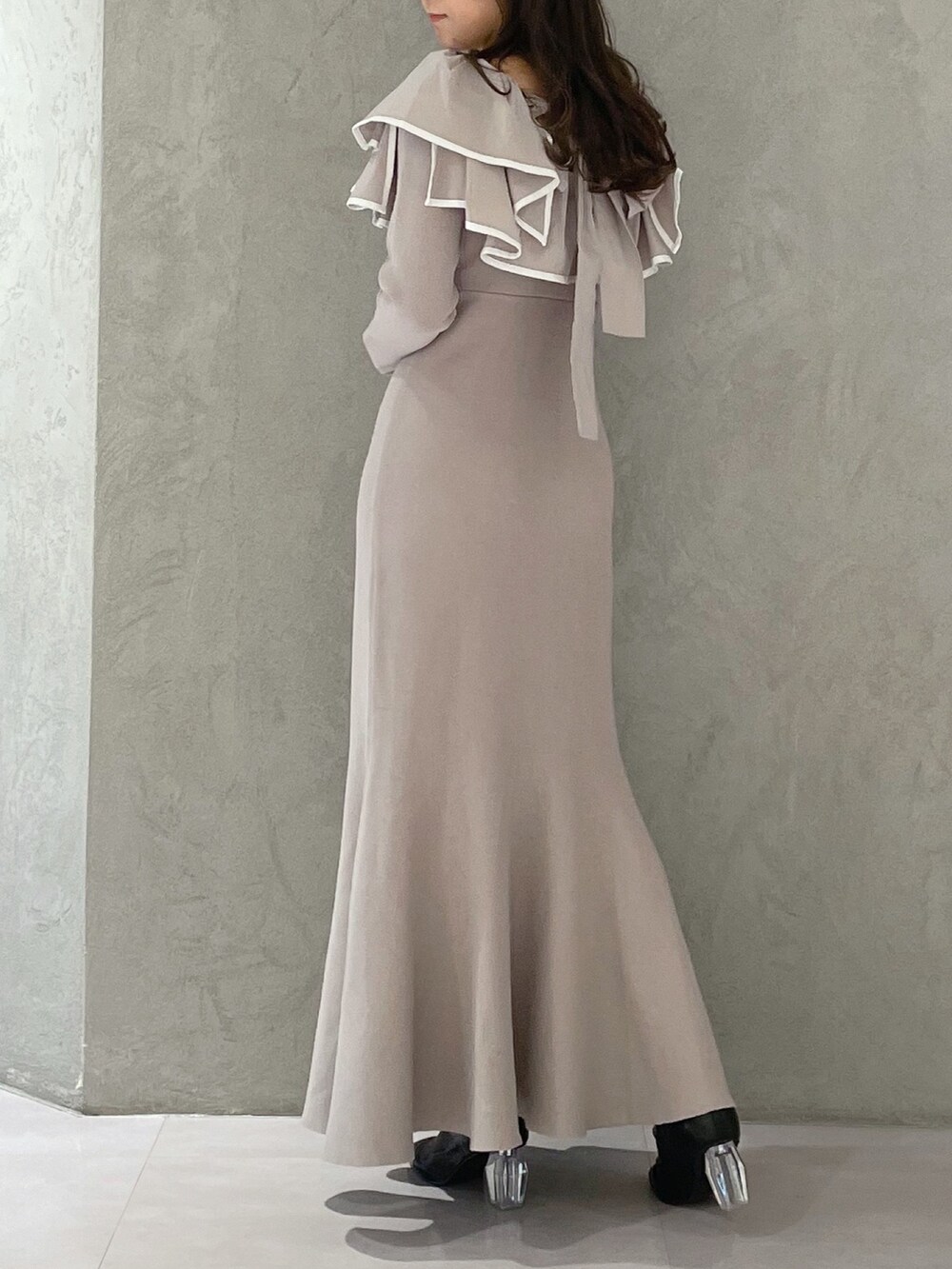 ベージュ系のワンピース、ホワイト系のチェスターコート、ブラック系のブーツを着用したレディースの冬コーディネートの5枚目の写真