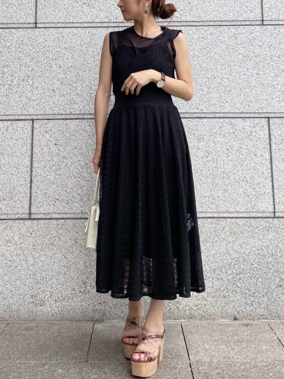 ベージュ系のサンダル、ブラック系のワンピースを着用したレディースの夏コーディネートの2枚目の写真