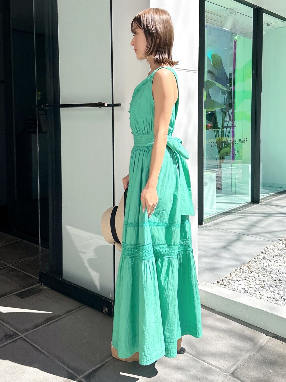 グリーン系のワンピース、その他のサンダルを着用したレディースの春コーディネートの3枚目の写真