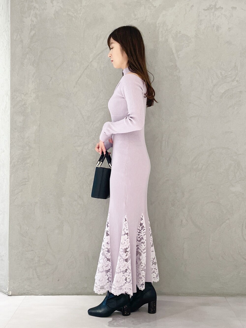 ピンク系のワンピース、ブラック系のブーツ、ブラック系のハンドバッグを着用したレディースの冬コーディネートの3枚目の写真