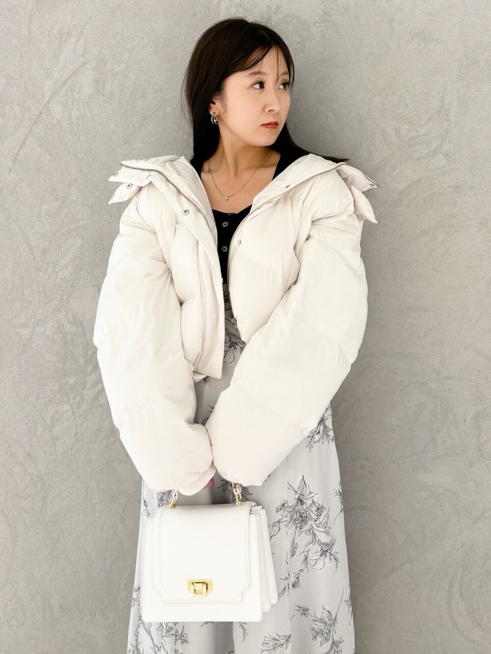 ブラック系のワンピース、ブラック系のブーツ、ホワイト系のハンドバッグを着用したレディースの秋コーディネートの5枚目の写真