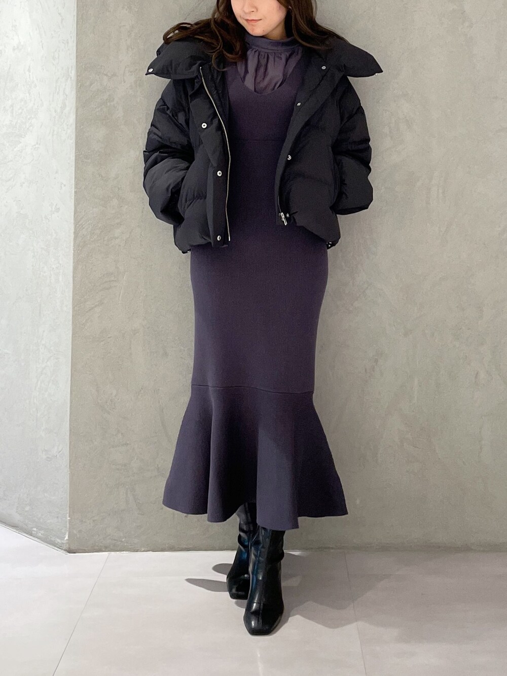 ブラック系のダウンジャケット/コート、ブルー系のワンピース、ブラック系のブーツを着用したレディースの冬コーディネートの6枚目の写真