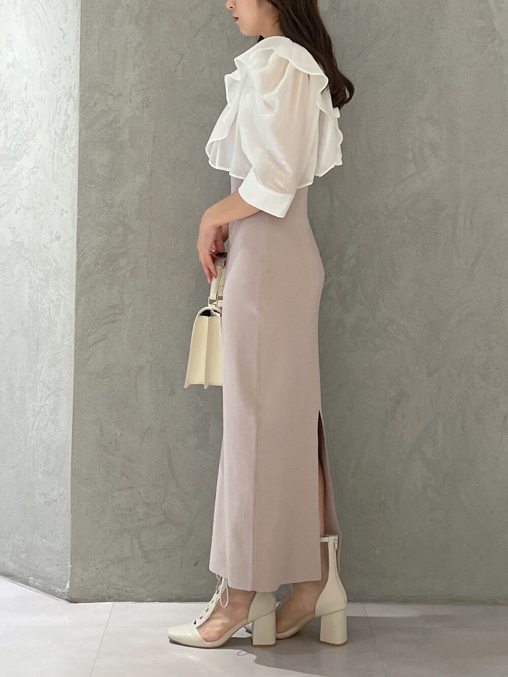 ベージュ系のワンピース、ホワイト系のブーツ、ホワイト系のハンドバッグを着用したレディースの夏コーディネートの4枚目の写真