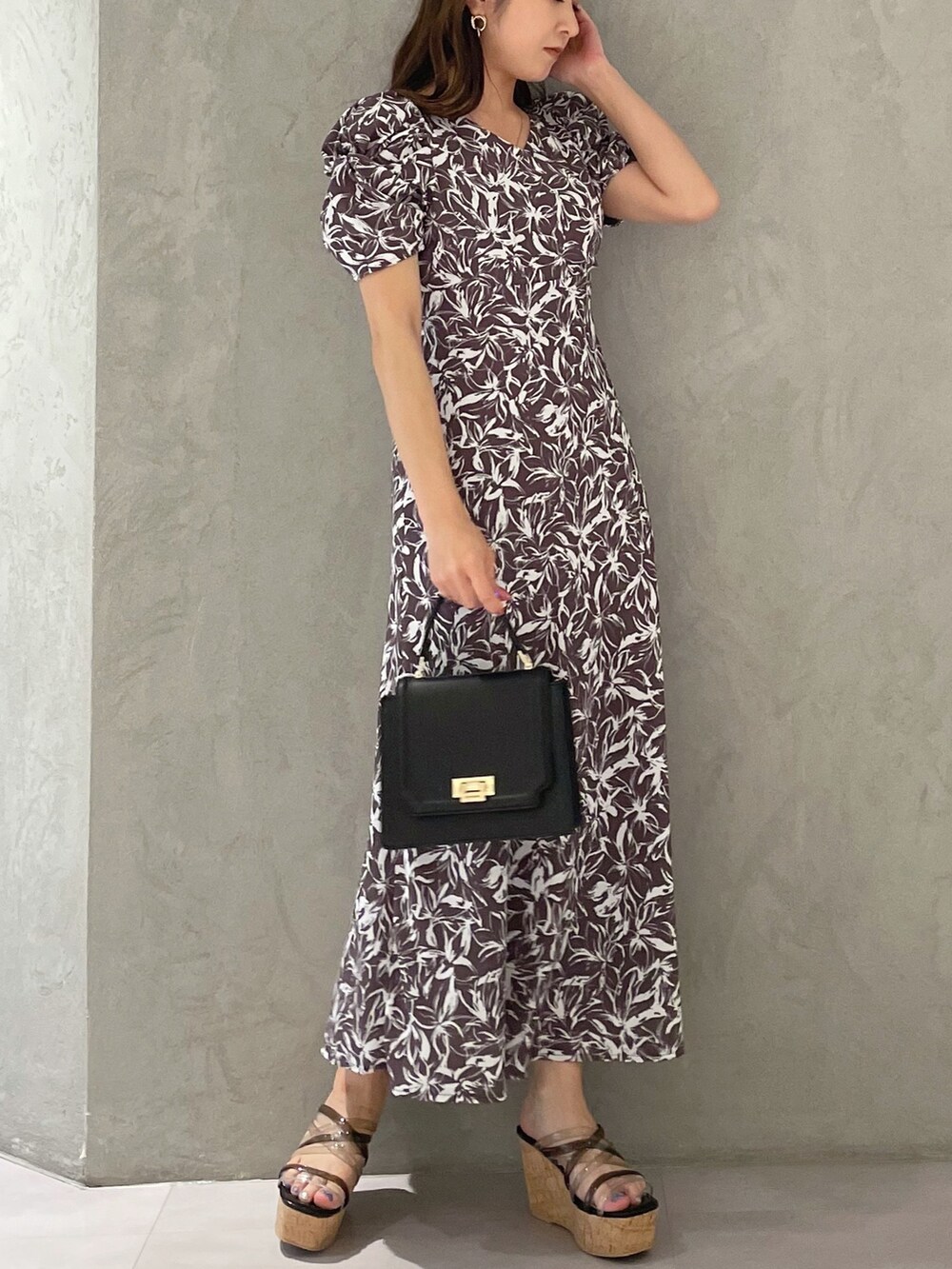 ブラック系のサンダル、ブラック系のハンドバッグ、グレー系のワンピースを着用したレディースの春コーディネートの4枚目の写真