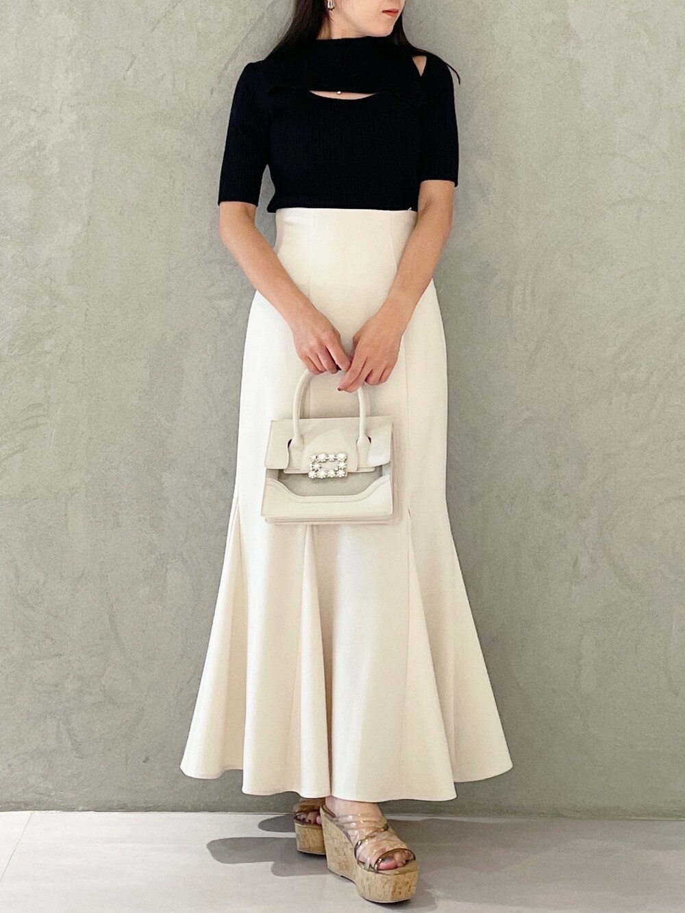 ピンク系のスカート、ブラウン系のサンダル、ベージュ系のショルダーバッグを着用したレディースの夏コーディネートの6枚目の写真