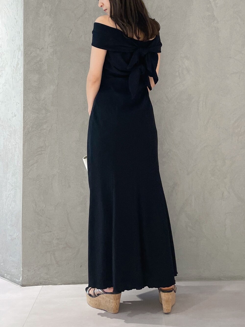 ホワイト系のトートバッグ、ブラック系のサンダル、ブラック系のワンピースを着用したレディースの夏コーディネートの2枚目の写真