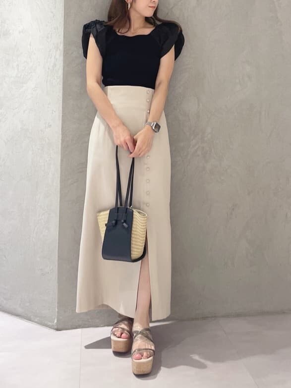 グリーン系のサンダル、ブラック系のニット/セーター、ベージュ系のスカートを着用したレディースの夏コーディネートの8枚目の写真