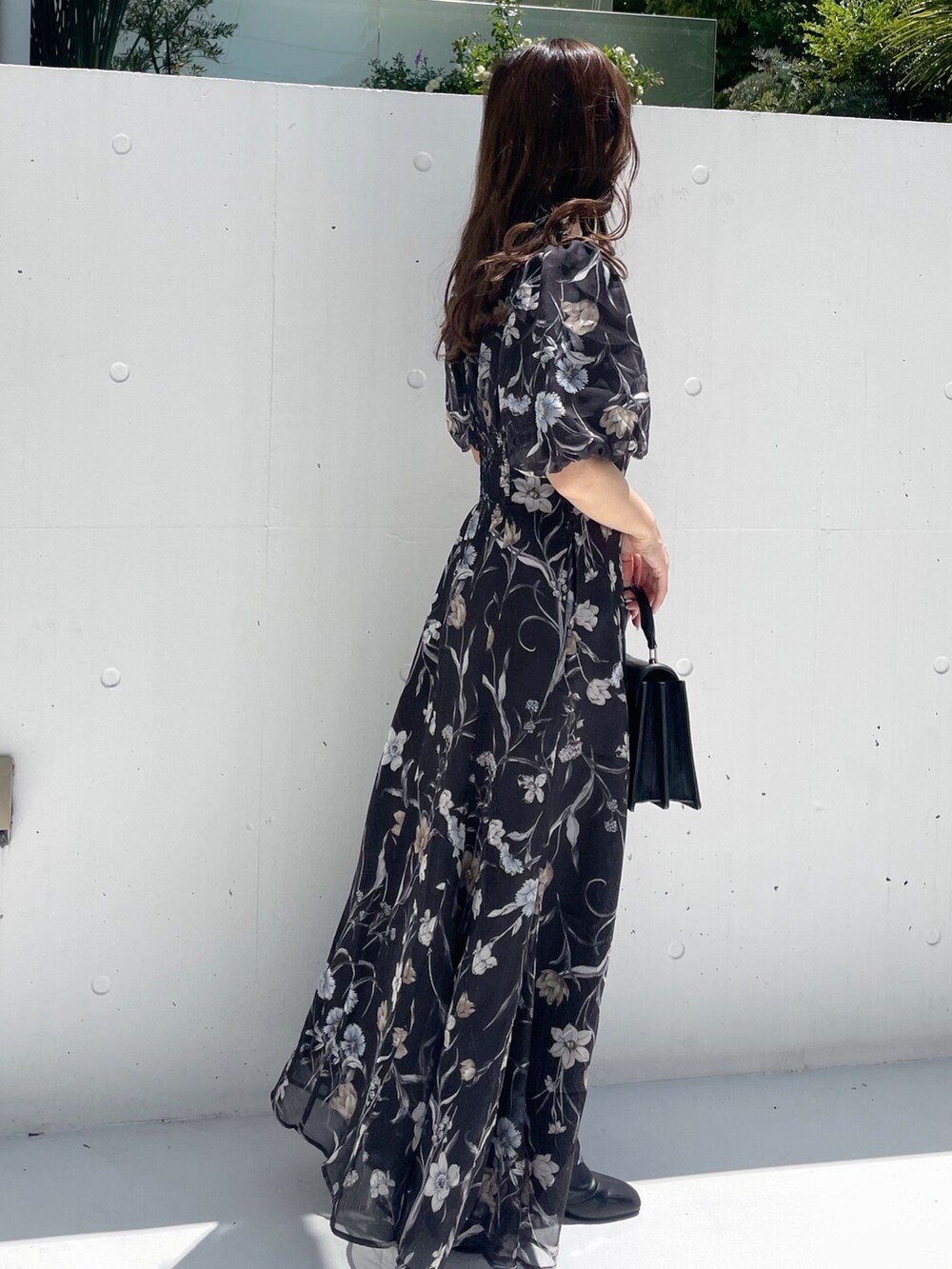 ブラック系のハンドバッグ、ブラック系のワンピースを着用したレディースの夏コーディネートの5枚目の写真