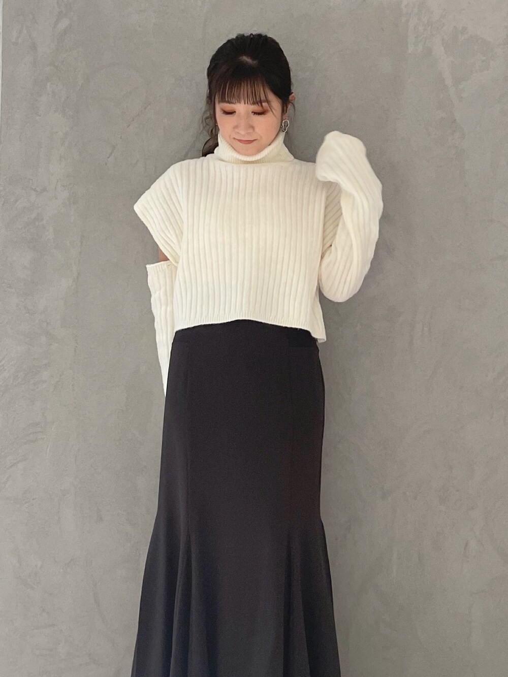 ブラウン系のスカート、ホワイト系のニット/セーターを着用したレディースの冬コーディネートの3枚目の写真