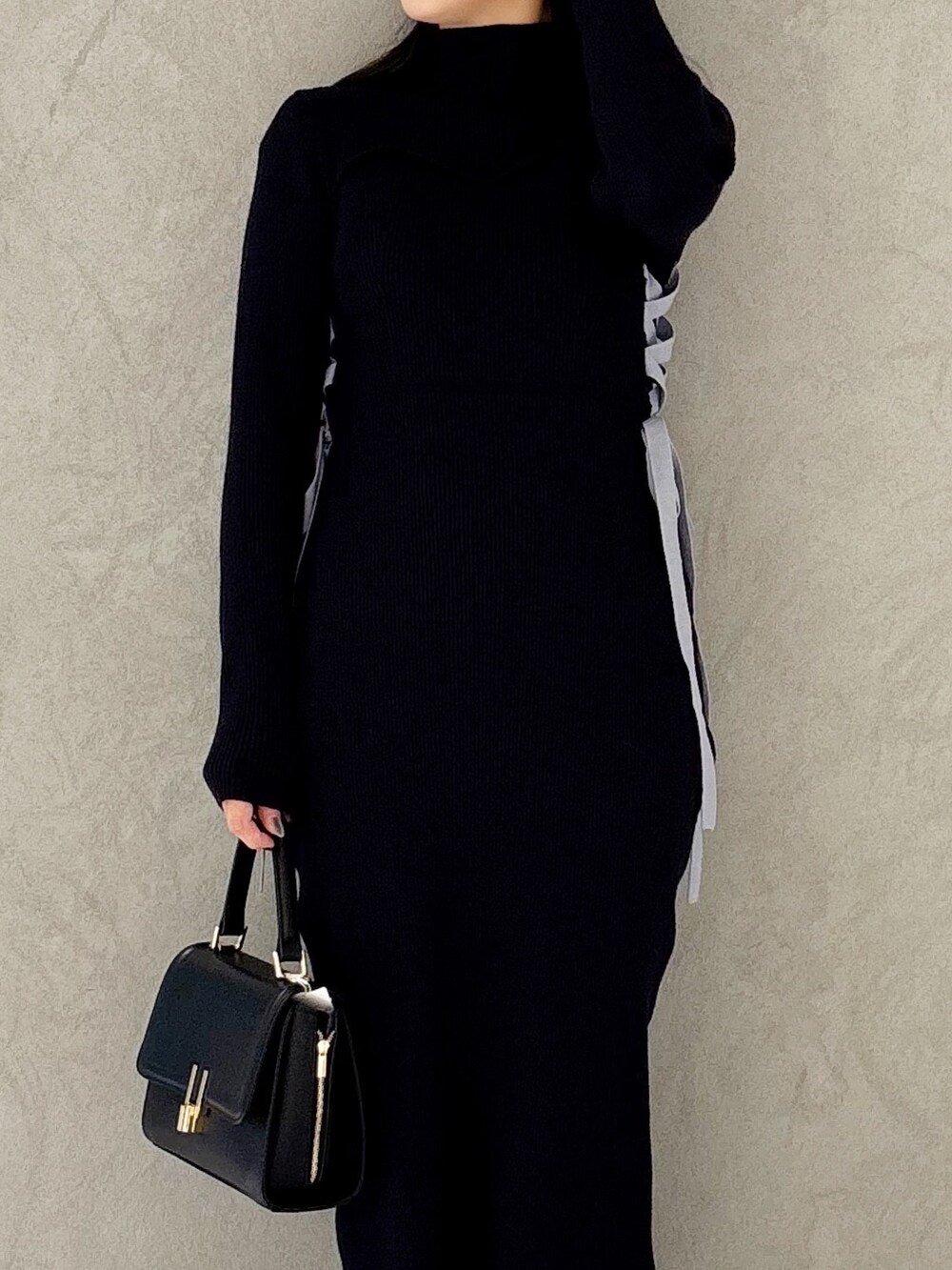 ブルー系のワンピース、ブラック系のブーツ、ブラック系のショルダーバッグを着用したレディースの冬コーディネートの5枚目の写真