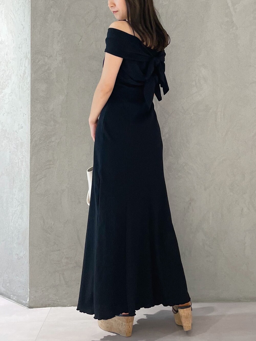 ホワイト系のトートバッグ、ブラック系のサンダル、ブラック系のワンピースを着用したレディースの夏コーディネートの7枚目の写真