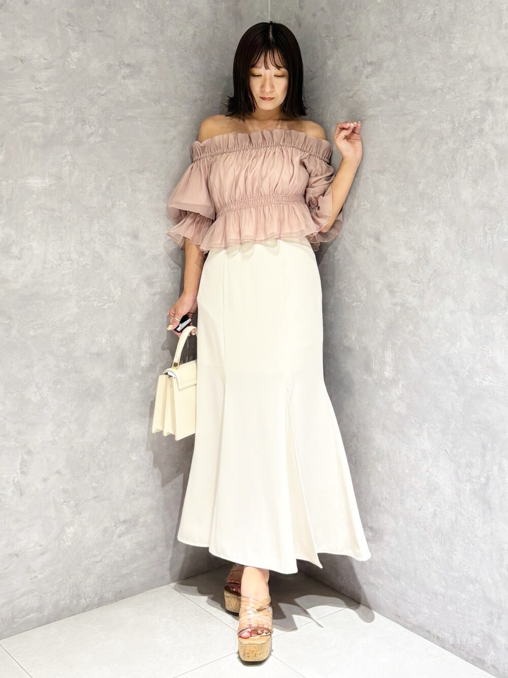 ホワイト系のスカート、ブラウン系のサンダル、ホワイト系のハンドバッグを着用したレディースの夏コーディネートの7枚目の写真