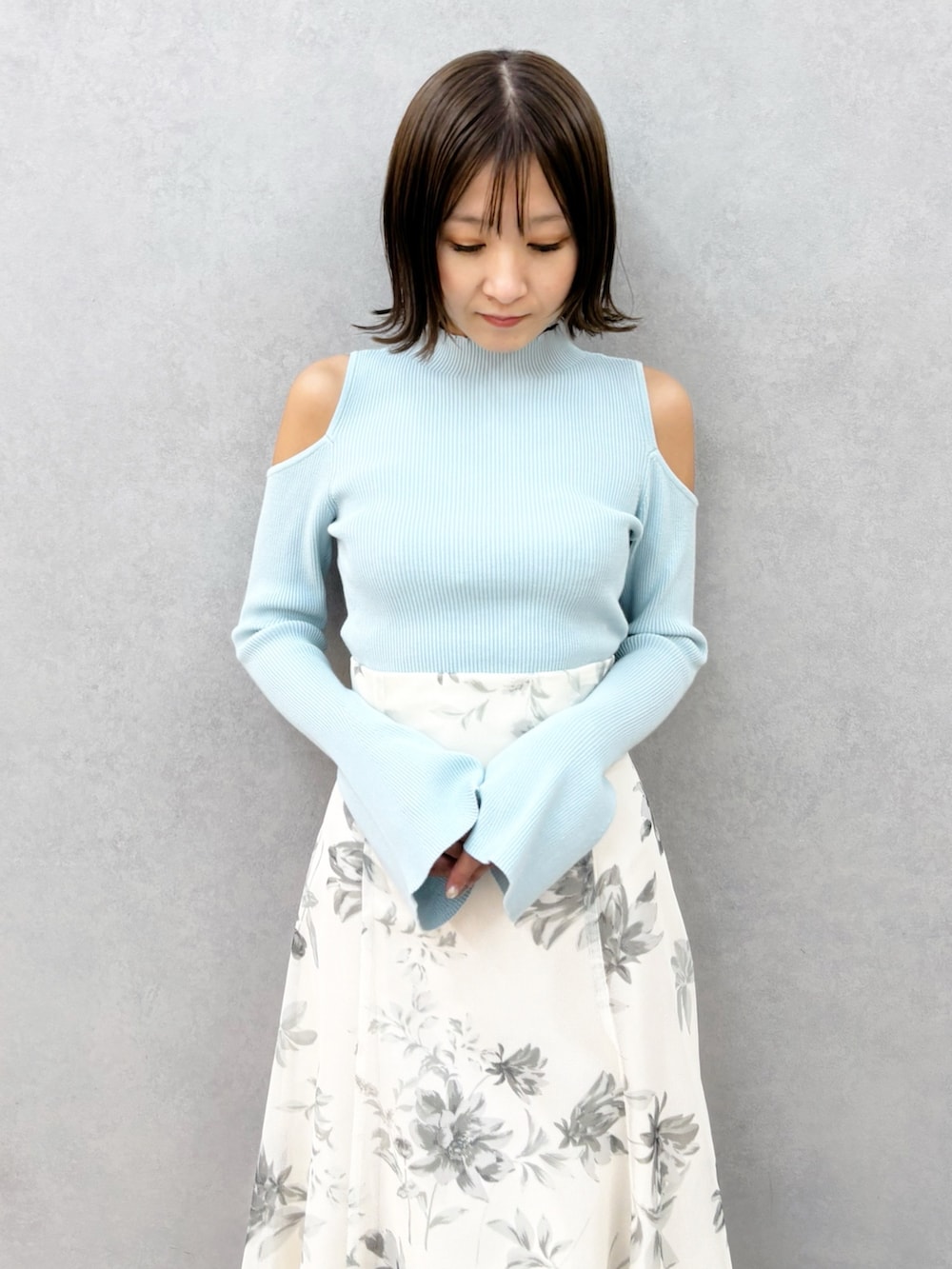 ホワイト系のスカート、グリーン系のニット/セーター、ホワイト系のパンプスを着用したレディースの春コーディネートの8枚目の写真