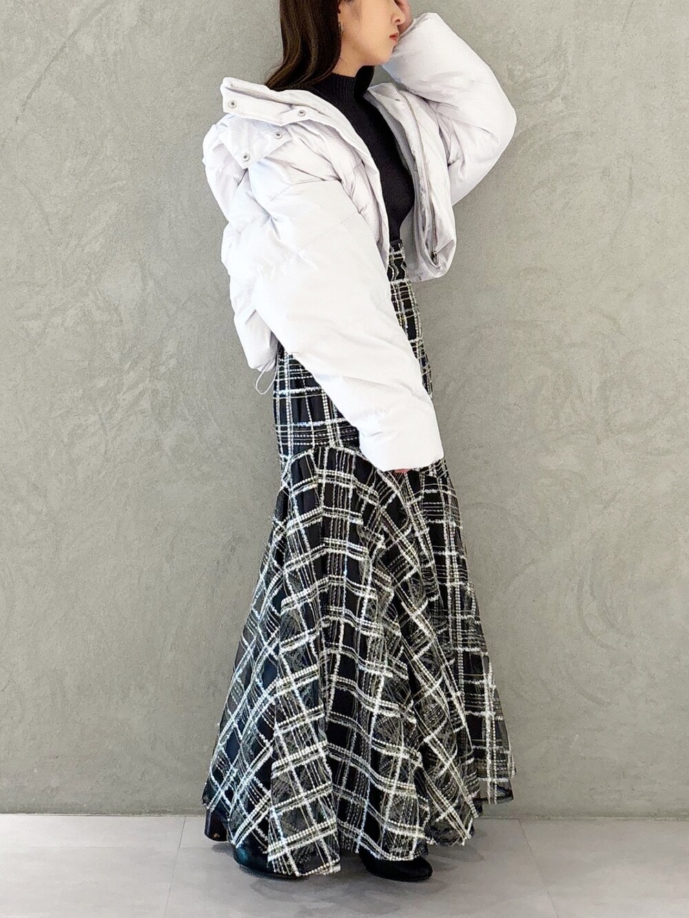 ブラック系のスカート、ブラック系のブーツ、グレー系のニット/セーターを着用したレディースの秋コーディネートの5枚目の写真