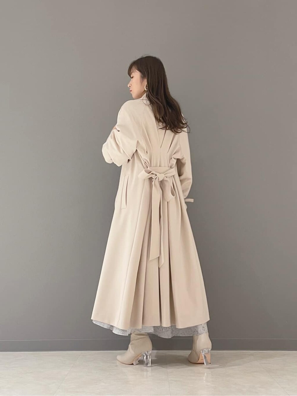 ベージュ系のその他シューズ、ベージュ系のトレンチコート、ブルー系のワンピースを着用したレディースの冬コーディネートの6枚目の写真