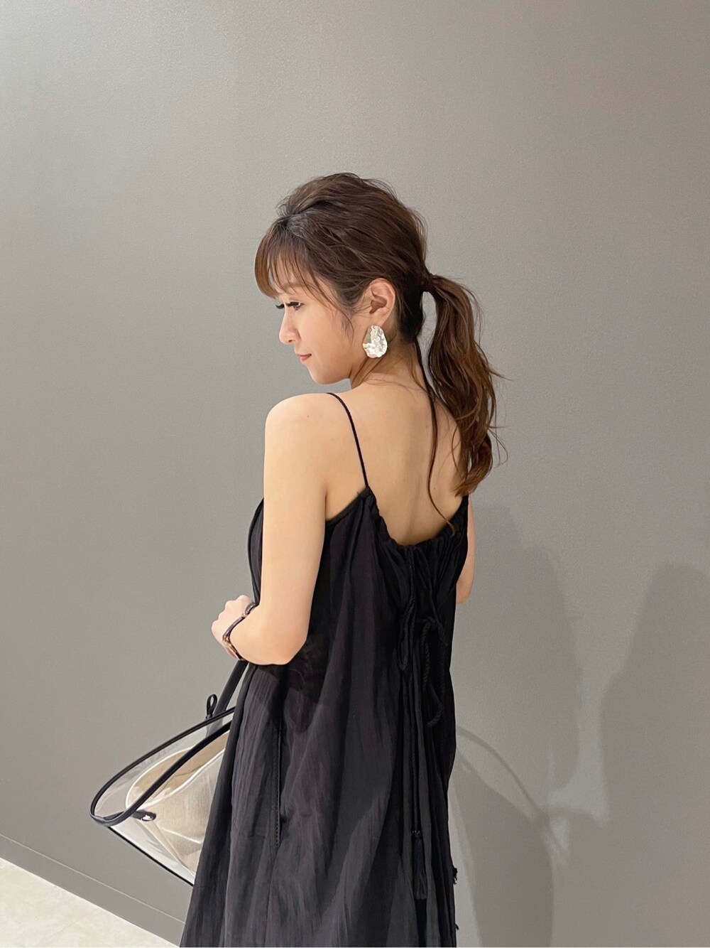 ブラック系のトートバッグ、ブラック系のワンピース、ブラウン系のサンダルを着用したレディースの春コーディネートの3枚目の写真