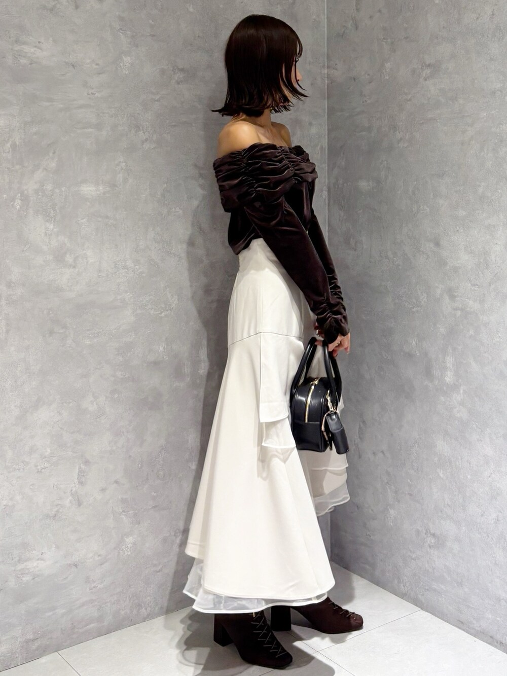 ベージュ系のスカート、ブラウン系のブーツ、ブラウン系のTシャツ/カットソーを着用したレディースの秋コーディネートの2枚目の写真