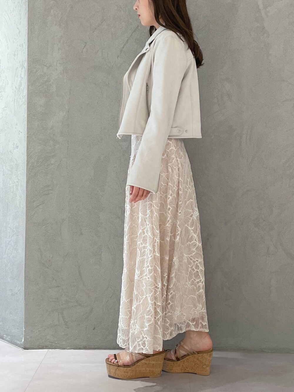 ブラウン系のサンダル、ホワイト系のニット/セーター、ホワイト系のライダースジャケットを着用したレディースの春コーディネートの4枚目の写真