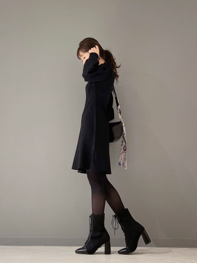 ブラック系のブルゾン、ブラック系のワンピース、ブラック系のブーツを着用したレディースの冬コーディネートの6枚目の写真