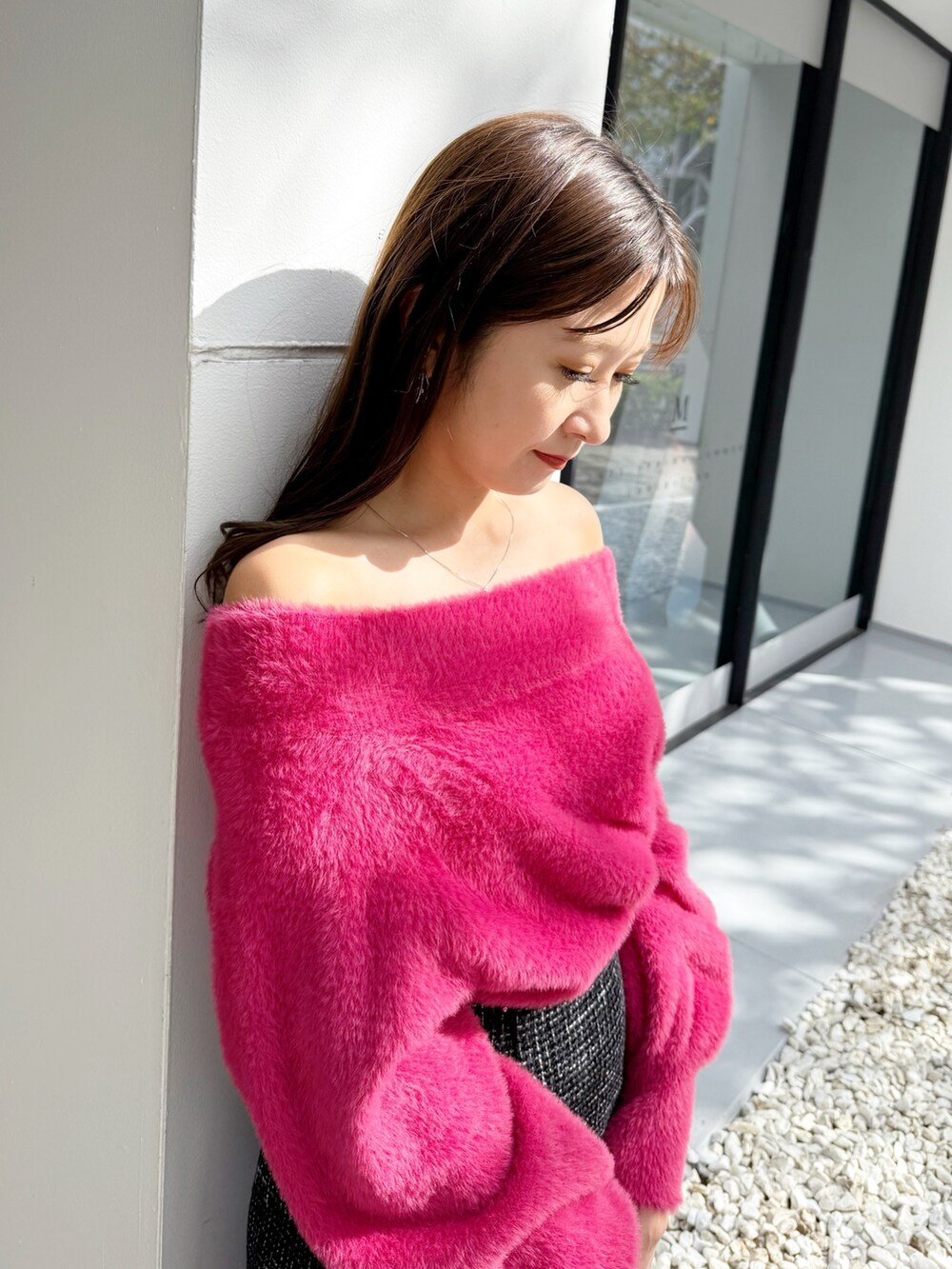 ブラック系のスカート、ブラック系のブーツ、シルバー系のハンドバッグを着用したレディースの秋コーディネートの6枚目の写真