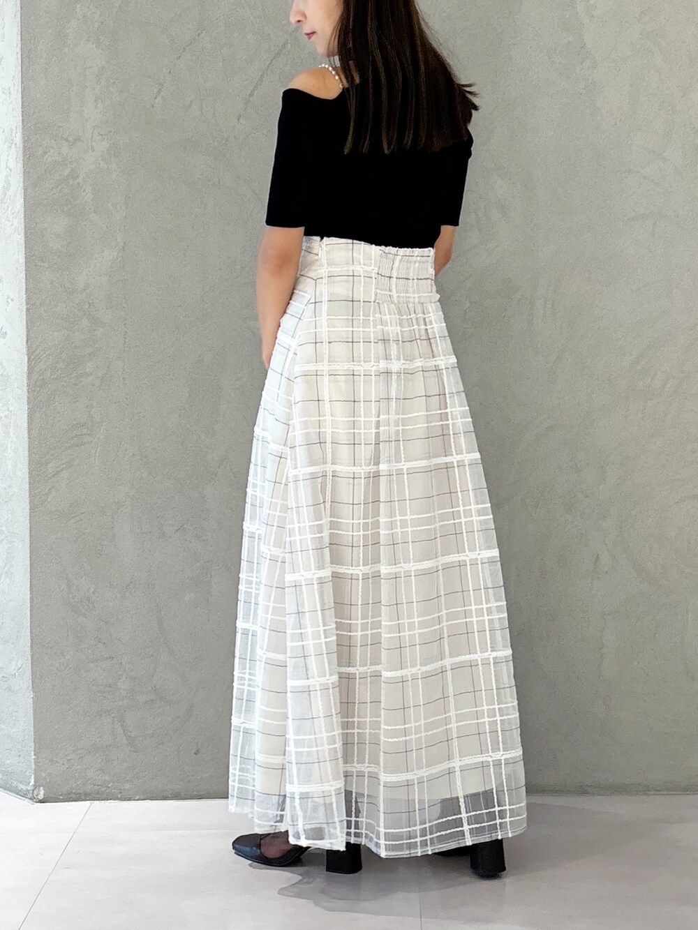 ホワイト系のスカート、ブラウン系のブーツ、ホワイト系のショルダーバッグを着用したレディースの秋コーディネートの3枚目の写真