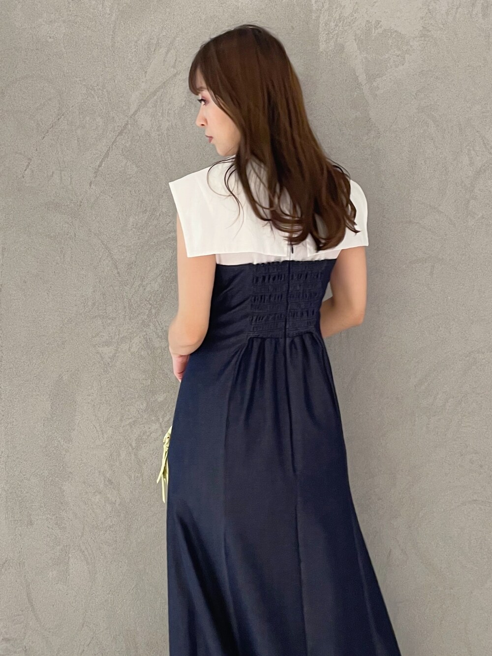 ブルー系のワンピース、イエロー系のボストンバッグ、ブラック系のサンダルを着用したレディースの春コーディネートの4枚目の写真