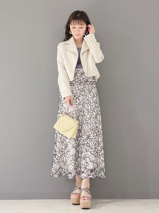 イエロー系のショルダーバッグ、ホワイト系のテーラードジャケット、グリーン系のサンダルを着用したレディースの春コーディネートの3枚目の写真