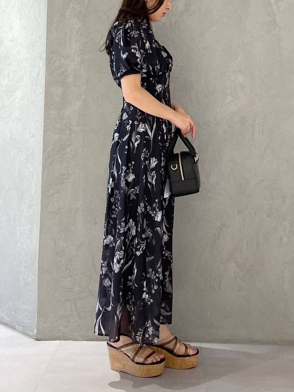 グレー系のワンピース、ブラック系のサンダルを着用したレディースの春コーディネートの3枚目の写真