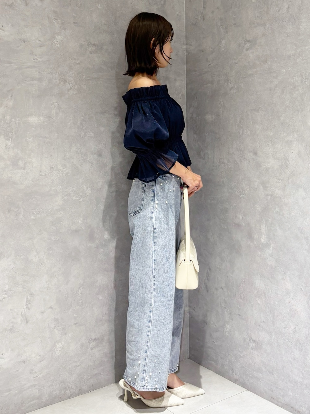 ブルー系のデニムパンツ、ブルー系のシャツ/ブラウス、ホワイト系のハンドバッグを着用したレディースの春コーディネートの3枚目の写真