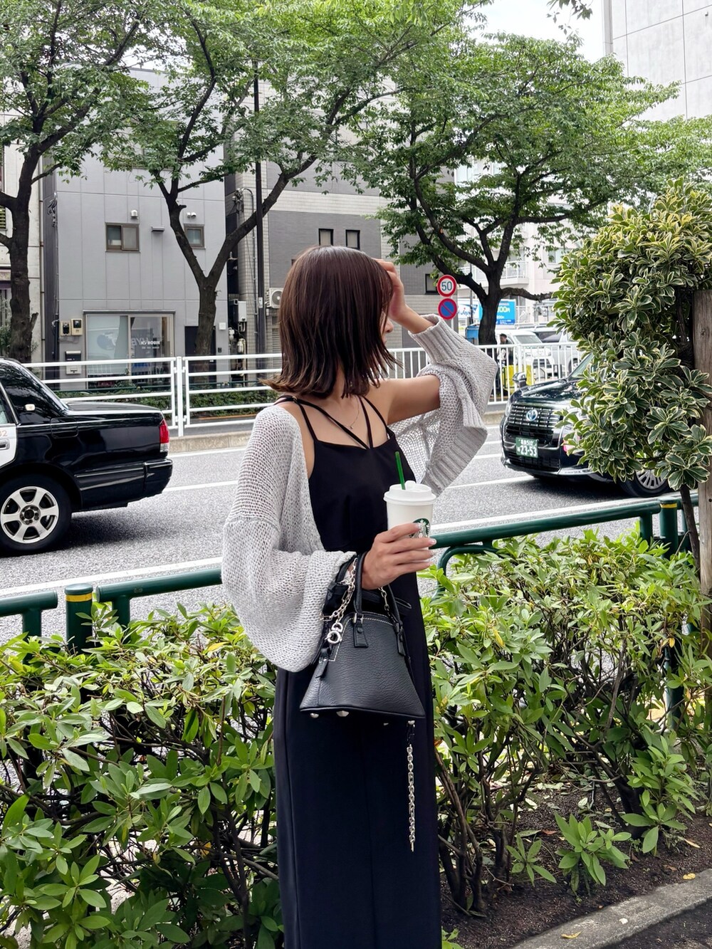 ブラック系のワンピース、グレー系のカーディガン/ボレロを着用したレディースの夏コーディネートの9枚目の写真