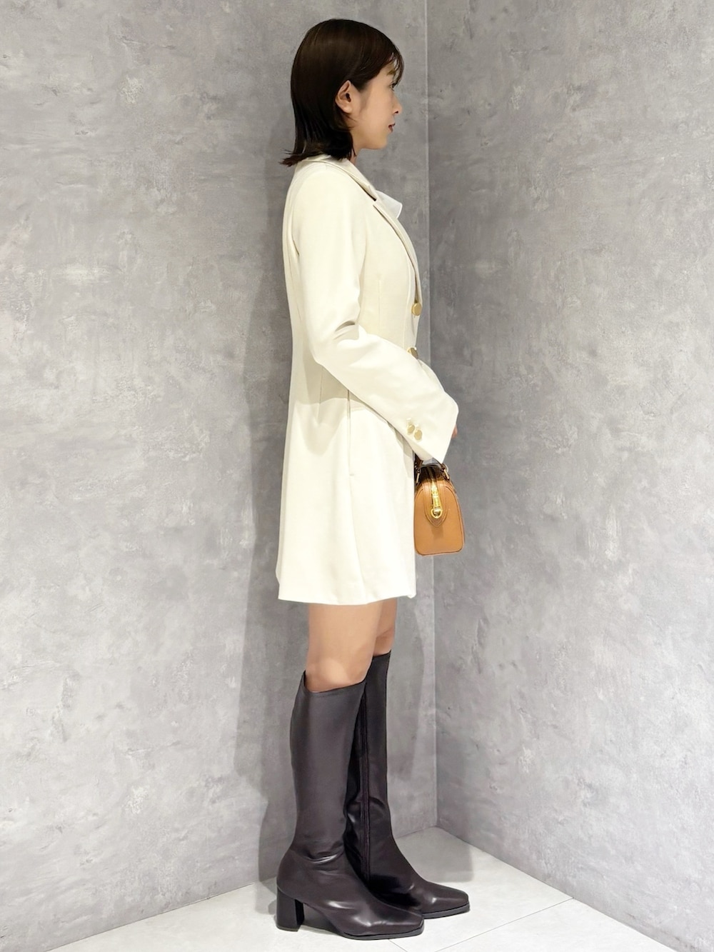 ホワイト系のワンピース、ホワイト系のシャツ/ブラウス、ブラウン系のハンドバッグを着用したレディースの春コーディネートの3枚目の写真