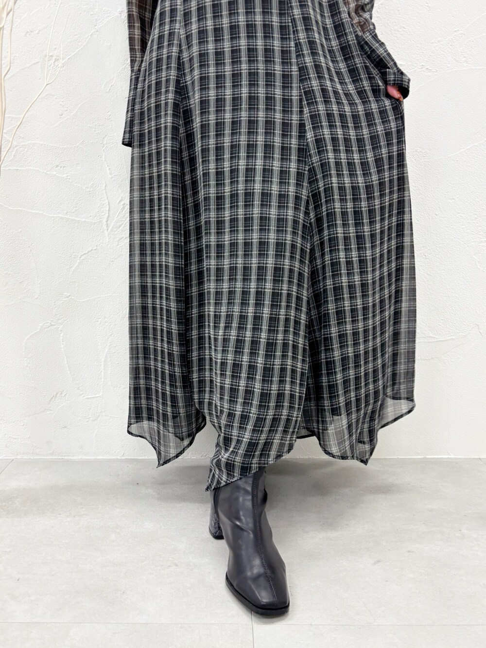 ブラック系のワンピース、ブラック系のブーツを着用したレディースの秋コーディネートの5枚目の写真