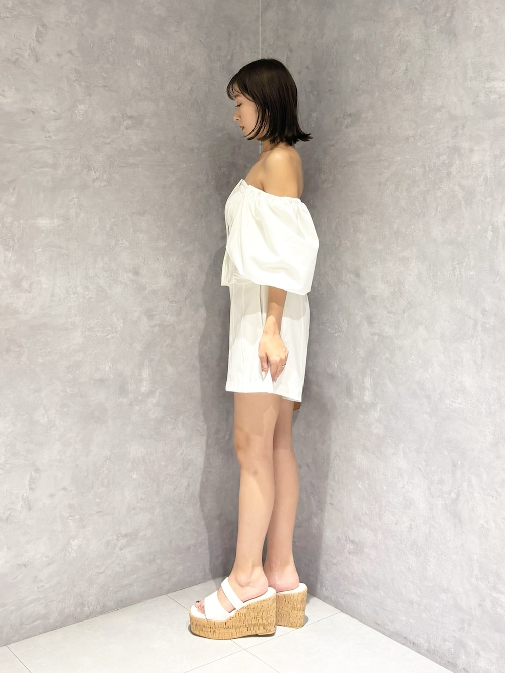 ホワイト系のその他パンツ、ホワイト系のサンダル、ブラウン系のハンドバッグを着用したレディースの夏コーディネートの4枚目の写真