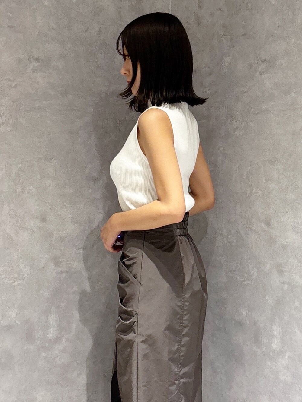 ブラウン系のスカート、ホワイト系のサンダル、ホワイト系のニット/セーターを着用したレディースの夏コーディネートの3枚目の写真