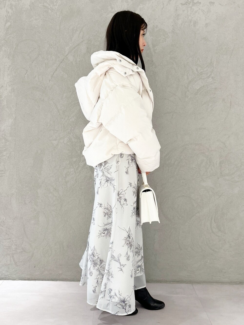 ブラック系のワンピース、ブラック系のブーツ、ホワイト系のハンドバッグを着用したレディースの秋コーディネートの6枚目の写真