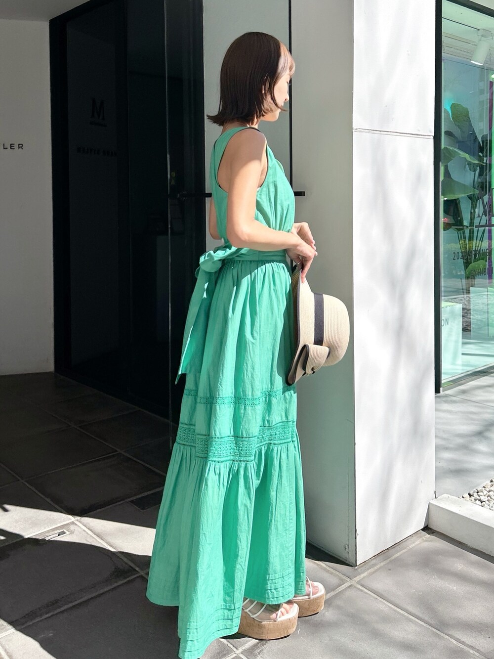 グリーン系のワンピース、その他のサンダルを着用したレディースの春コーディネートの2枚目の写真