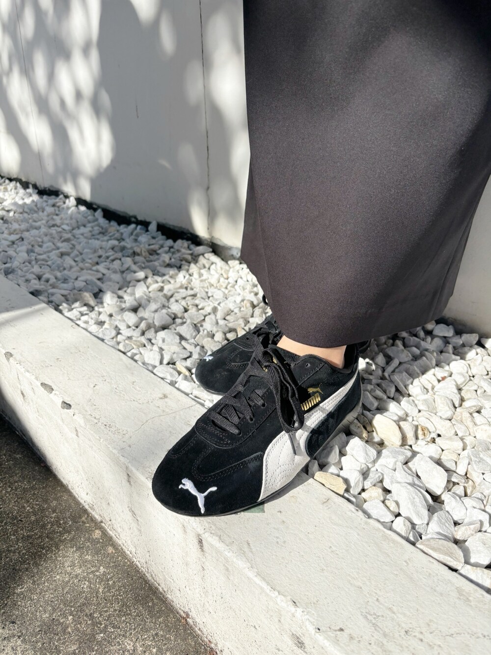 ブラック系のスカート、ブラック系のスニーカー、グレー系のニット/セーターを着用したレディースの秋コーディネートの7枚目の写真