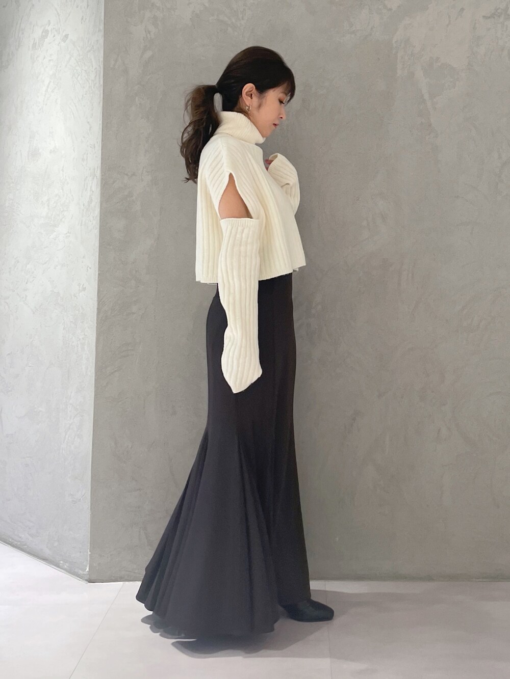 ブラウン系のスカート、ホワイト系のニット/セーターを着用したレディースの冬コーディネートの4枚目の写真