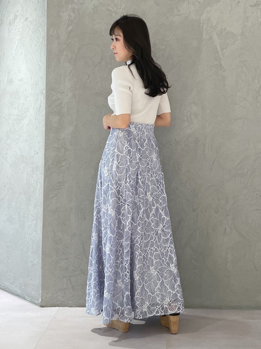 ブルー系のスカート、ブラック系のサンダル、ホワイト系のニット/セーターを着用したレディースの春コーディネートの5枚目の写真