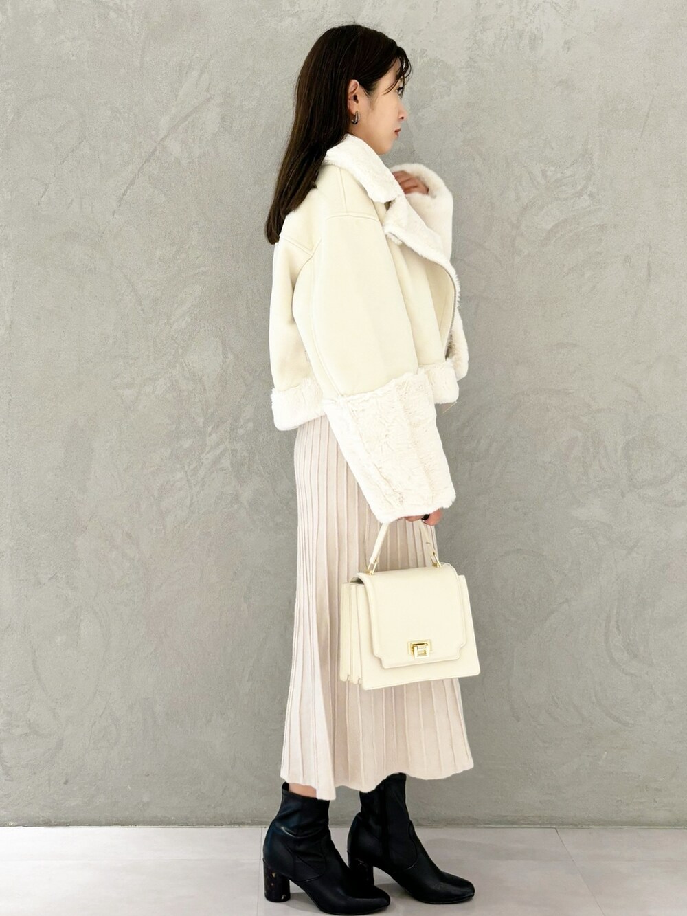 ホワイト系のワンピース、ブラック系のブーツ、ホワイト系のハンドバッグを着用したレディースの秋コーディネートの8枚目の写真